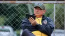 Manajer Timnas Indonesia U-22, Sumardji, tampak serius menyaksikan laga Timnas Vietnam U-22 vs Timnas Malaysia U-22 dari layar handphone. (Bola.com/Bagaskara Lazuardi)