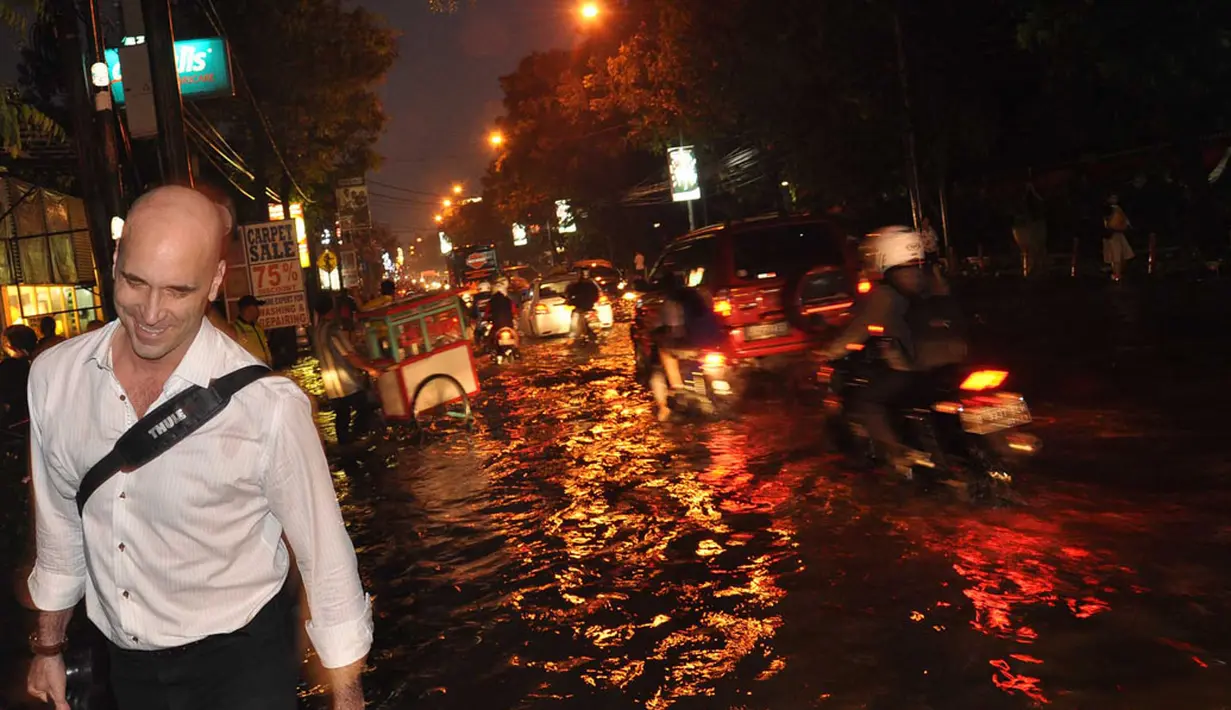 Salah satu warga asing tersenyum saat melintasi kawasan Kemang yang dilanda banjir pada Senin, (11/8/2014). (Liputan6.com/Miftahul Hayat)