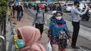Sejumlah orang berjalan di trotoar pada saat jam pulang kantor di Kawasan Sudirman, Jakarta, Senin (8/6/2020). Aktivitas perkantoran dimulai kembali pada pekan kedua penerapan Pembatasan Sosial Berskala Besar (PSBB) transisi pandemi COVID-19. (Liputan6.com/Johan Tallo)