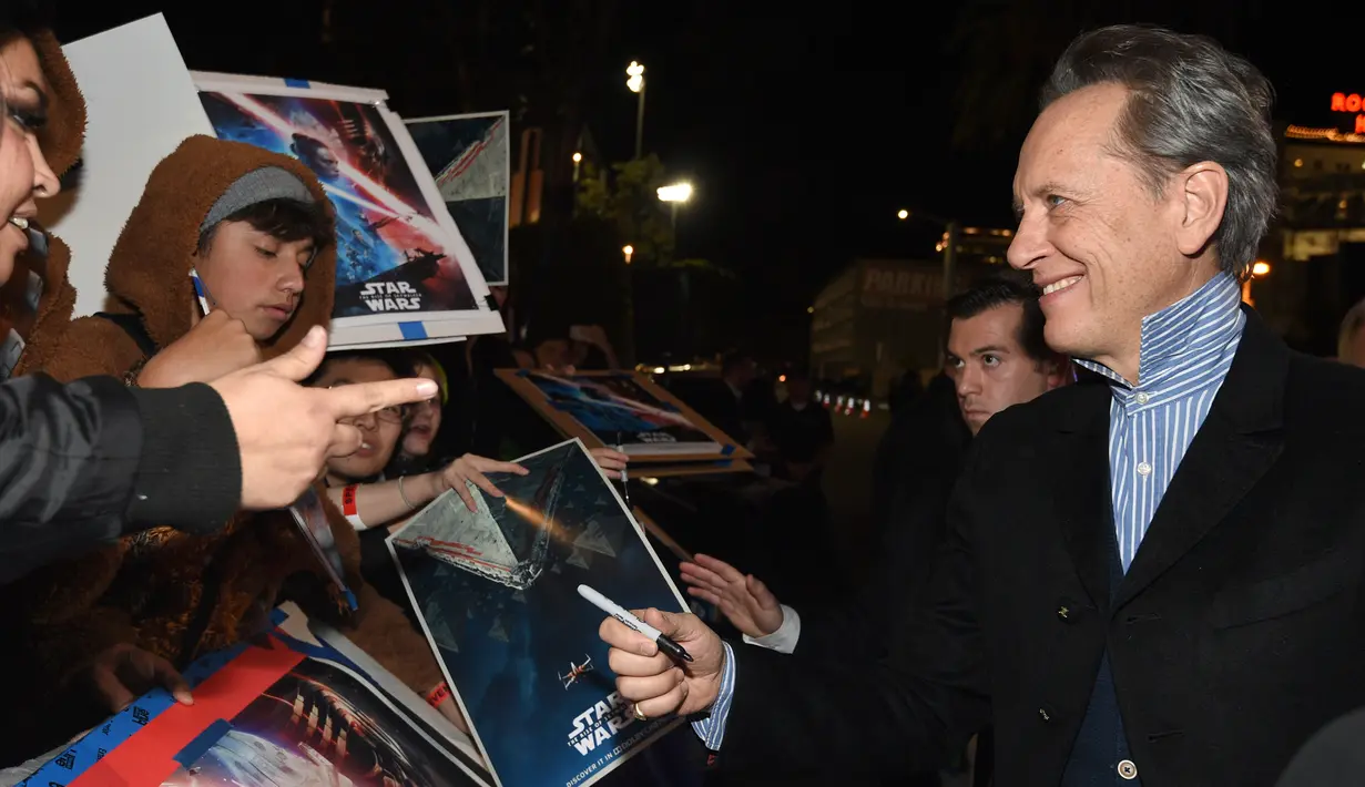 Aktor Richard E. Grant memberikan tanda kepada penggemar saat menghadiri pemutaran perdana "Star Wars: The Rise Of Skywalker" di Los Angeles, Senin (16/12/2019). The Rise Of Skywalker sendiri mengisahkan pertarungan antara terang dan gelap, Rey dan Kylo Ren. (AP Photo/Chris Pizzello)
