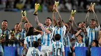 Lionel Messi dan rekan setimnya mengangkat trofi Piala Dunia saat merayakan kemenangan Argentina atas Panama pada pertandingan laga persahabatan di Stadion Monumental, Buenos Aires, Argentina, Kamis (23/3/2023). (AP Photo/Natacha Pisarenko)