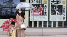 Warga yang mengenakan masker untuk melindungi diri dari penyebaran COVID-19 berjalan melewati laporan raihan medali emas Jepang di Olimpiade Tokyo 2020, Tokyo, Selasa (27/7/2021). Tokyo melaporkan jumlah kasus harian COVID-19 tertinggi beberapa hari setelah Olimpiade mulai. (AP Photo/Koji Sasahara)