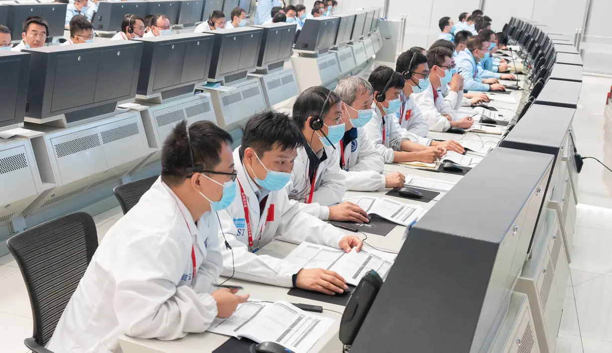 Para personel teknis bekerja di Pusat Kendali Antariksa Beijing (Beijing Aerospace Control Center/BACC) di Beijing, ibu kota China (9/10/2020). Wahana penjelajah tersebut menyelesaikan manuver orbital pada pukul 23.00 setelah mesin utamanya bekerja selama lebih dari 480 detik. (Xinhua/Cai Yang)