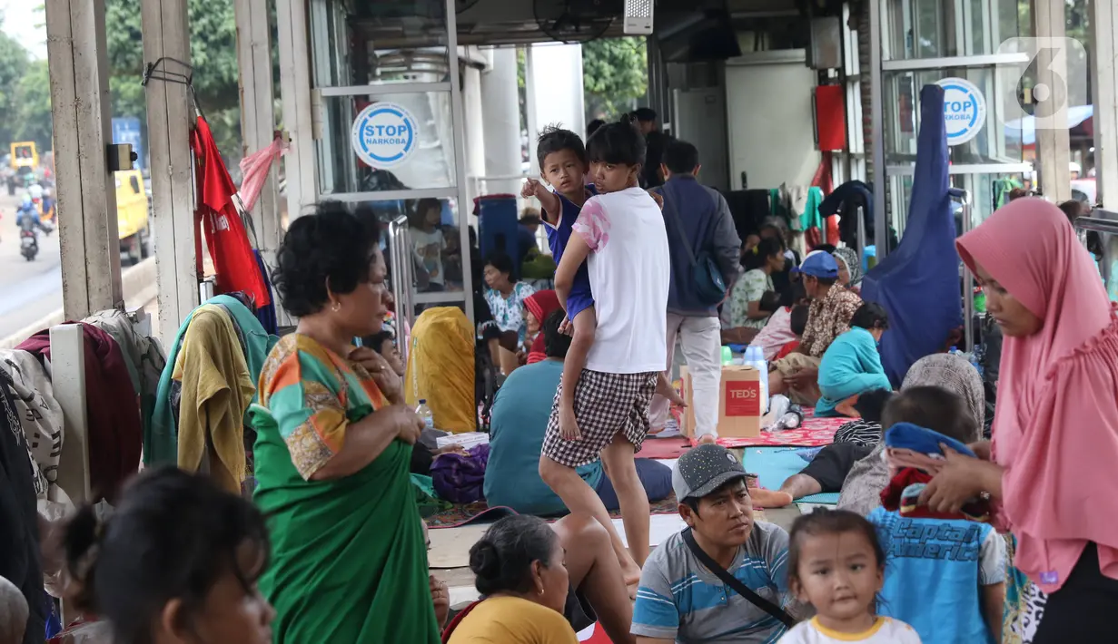 Warga korban banjir mengungsi di Halte Transjakarta Jembatan Baru, Cengkareng, Jakarta, Jumat (3/1/2020). Warga sekitar terpaksa mengungsi ke Halte Transjakarta Jembatan Baru karena rumah mereka masih terendam banjir. (Liputan6.com/Angga Yuniar)