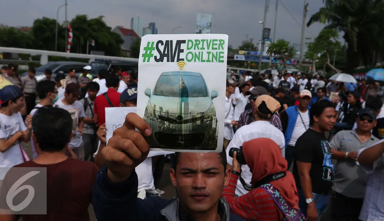 Seorang driver online memperlihatkan poster yang berisi tuntutannya saat unjuk rasa di depan DPR, Jakarta, Senin (22/8). Aksi tersebut untuk penolakan Peraturan Menteri Perhubungan (Permenhub) No 32 Tahun 3016. (Liputan6.com/Angga Yuniar)