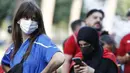 Walaupun harus menonton diluar stadion mereka pun tetap patuh pada protokol kesehatan salah satunya dengan memakai masker yang tak mengurangi kecantikan mereka. (Foto: AP/LaPresse/Cecilia Fabiano)