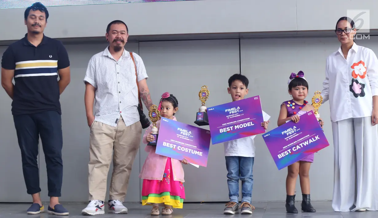 Tiga orang anak didampingi orangtua berpose dengan piala dan piagam usai menjuarai Kids Modeling Competition dalam acara Fimela Fest 2018, Jakarta, Minggu (18/11). (Fimela.com/Nurwahyunan Nur)