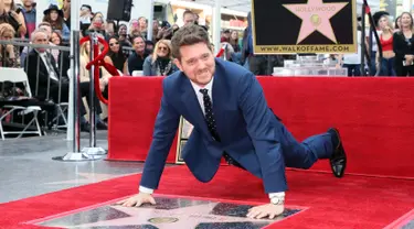 Michael Buble berpose di dekat bintang Hollywood Walk Of Fame miliknya saat acara penghargaan di Hollywood, California (16/11). Penyanyi Jazz asal Kanada ini merupakan penerima bintang ke 2,650 di Hollywood Walk Of Fame. (AFP Photo/David Livingston)