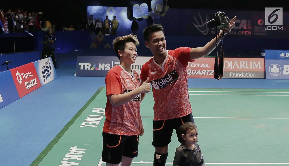 Ganda Campuran Indonesia, Tontowi Ahmad/Liliyana Natsir berswafoto menggunakan kamera wartawan usai mengalahkan Ganda Campuran asal China Zheng Siwei/Chen Qingchen dalam final BCA Indonesia Open 2017 di Jakarta, Minggu (18/6). (Liputan6.com/Faizal Fanani)