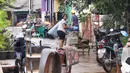 Warga membersihkan barangnya yang kotor akibat terendam banjir di perumahan Ciledug Indah, Tangerang, Senin (21/2/2021). Banjir yang menggenangi perumahan itu membuat warga mengalami kerugian cukup besar karena barang-barang berharga mereka rusak parah. (Liputan6.com/Angga Yuniar)