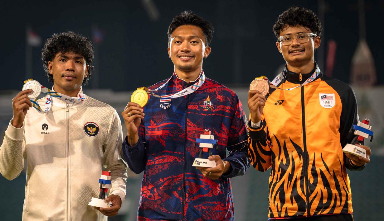 Lalu Muhammad Zohri mencatatkan waktu 10,25 detik, sementara Puripol mencatatkan 10,00 detik. Tampak dalam foto, Puripol Boonson dari Thailand (tengah) berpose untuk foto dengan medali emasnya di samping peraih medali perak Lalu Muhammad Zohri dari Indonesia (kiri) dan peraih medali perunggu Danish Iftikhar Muhammad Roslee dari Malaysia setelah final 100 meter putra cabang atletik pada SEA Games ke-33 di Suphachalasai National Stadium, Bangkok, pada Kamis 11 Desember 2025. (Chanakarn LAOSARAKHAM/AFP)