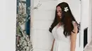 Memakai dress putih, Aura Kasih tampil dengan rambut panjang diurai. Untuk menyempurnakan penampilan, pemilik nama Sanny Aura Syahrani ini menyematkan bunga melati di telinganya. Tak dapat dipungkiri, kecantikannya pun semakin terpancar berpadu dengan keindahan bunga. (Liputan6.com/IG/@aurakasih)