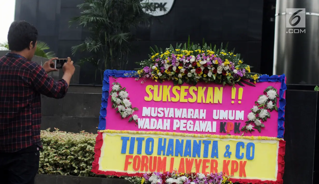 Warga mengambil gambar karangan bunga ucapan Musyawarah Umum Wadah Pegawai (WP) KPK dari Forum Lawyer KPK dan Tito Hananta di depan Gedung KPK, Jakarta, Kamis (3/5). Pertemuan membahas peralihan pengurus WP periode 2016-2018. (Merdeka.com/Dwi Narwoko)