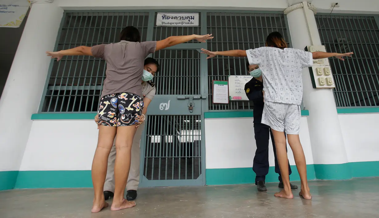 Petugas mengecek dua transgender sebelum memasuki sel penjara Pattaya Prison, Provinsi Choburi, Thailand (6/1). Di penjara ini narapidana LGBT dipisahkan dari narapidana lain untuk mencegah kekerasaan yang terjadi. (AP Photo/Sakchai Lalit)