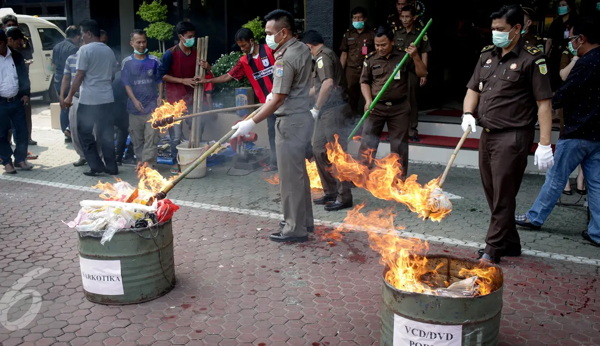 Petugas memusnahkan barang bukti persidangan dengan cara dibakar di Kejaksaan Negeri Jakarta Utara, Kamis (16/3). Narkotika mulai dari 2.645 gram ganja, 6.128 gram sabu, 43 gram, dan 212.336 butir extasy ikut dimusnahkan. (Liputan6.com/Faizal Fanani)