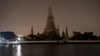 Kuil Wat Arun terlihat padam tanpa lampu penerangan saat peringatan Earth Hour Internasional di Bangkok, Thailand (25/3). Tahun ini gerakan Earth Hour melibatkan pemadaman listrik selama satu jam di 7.000 kota di 172 negara. (AFP/Roberto Schmidt)