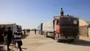 Sebelum Israel melancarkan perang di Gaza, Rafah merupakan jalur penyeberangan utama orang-orang yang keluar masuk wilayah Palestina. Tampak dalam foto, warga Palestina menyaksikan truk-truk yang membawa bantuan kemanusiaan tiba di Khan Yunis di Jalur Gaza selatan, setelah melewati penyeberangan perbatasan Rafah dari Mesir, pada 1 Februari 2026. (Bashar Taleb/AFP)