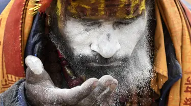 Seorang Sadhu (orang suci Hindu) mengoleskan wajahnya di dekat kuil Pashupatinath pada malam festival Hindu Maha Shivaratri di Kuil Pashupatinath di Kathmandu (20/2/2020). Maha Shivaratri, sebuah festival Hindu yang dirayakan sebelum kedatangan musim semi. (AFP/Prakash Mathema)