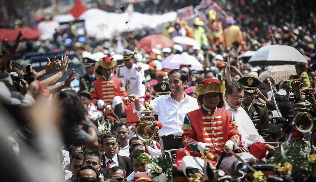 Kereta yang ditumpangi Jokowi-JK berjalan pelan membelah lautan manusia yang menyemut disepanjang Jalan MH Thamrin hingga Monas, Jakarta, (20/10/14). (Liputan6.com/Faizal Fanani)