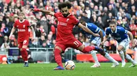 Penyerang Liverpool, Mohamed Salah, mengambil eksekusi penalti yang sukses membobol gawang Everton dalam laga pekan kesembilan Liga Inggris 2023/2024 di Anfield, Sabtu (21/10/2023) malam WIB. Liverpool menang 2-0 dalam laga ini. (Paul ELLIS / AFP)