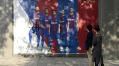 Fans melihat poster pemain Barcelona, Gerard Pique yang dirusak di sebuah toko yang ditutup sebagai bagian dari pemogokan oleh serikat pekerja Catalonia di luar stadion Camp Nou, Barcelona (3/10). (AFP Photo/Josep Lago)