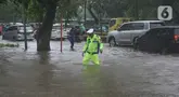 Polisi mengecek ketinggian genangan banjir yang menutupi Jalan Letjen Suprapto, Cempaka Putih, Jakarta Pusat, Kamis (29/2/2024). (merdeka.com/Arie Basuki)
