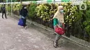 Sejumlah pasien Covid-19 berjalan memasuki bus sekolah di Puskesmas Kecamatan Ciracas, Jakarta, Kamis (10/06/2021). Kasus positif di Jakarta bertambah 2.096 orang, sehingga total kasus positif bertambah menjadi 440.554 orang. (Liputan6.com/Herman Zakharia)