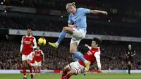 Pemain Manchester City, Erling Haaland berusaha mencetak gol ke gawang Arsenal pada laga pekan ke-23 Liga Inggris 2022/2023 yang berlangsung di Emirates Stadium, London, Kamis (16/02/2023) WIB. (AFP/Ian Kington)