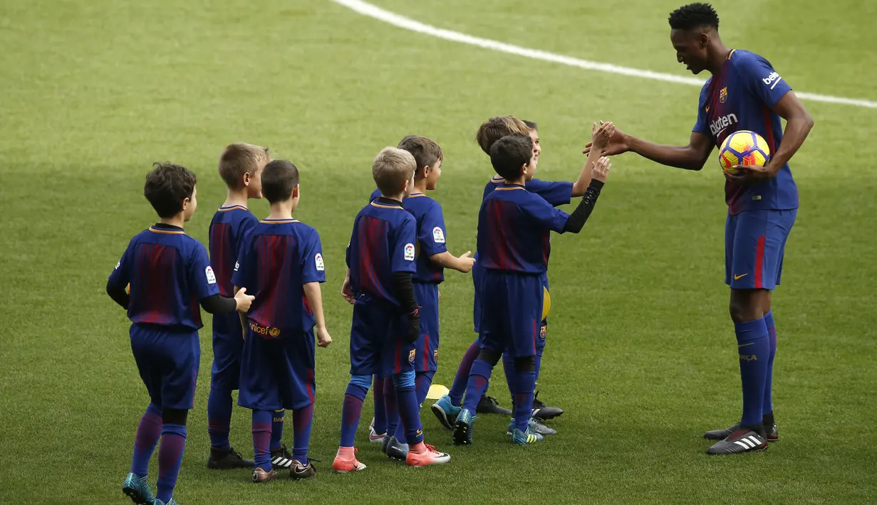 Yerry Mina bersalaman dengan anak-anak saat sesi perkenalan di Camp Nou stadium, Barcelona, (13/1/2018). Mina didatangkan Barcelona dari Palmeiras sebesar 10.5 juta pounds. (AP/Manu Fernandez)