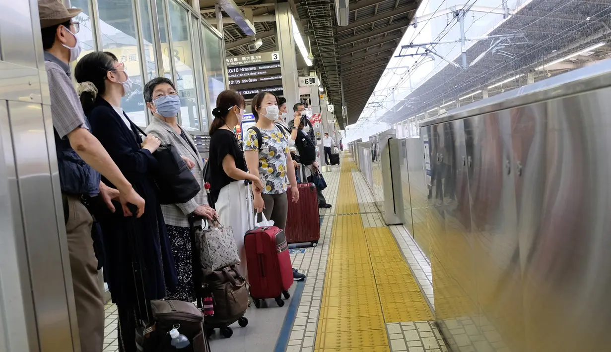 Penumpang menunggu kereta peluru Shinkansen di stasiun kereta Shin-Yokohama di Yokohama, Prefektur Kanagawa (22/7/2020). Kampanye "Go To Travel" menawarkan subsidi dan diskon untuk pelancong dalam menghidupkan industri pariwisata domestik yang dilanda pandemi COVID-19. (AFP Photo/Kazuhiro Nogi)
