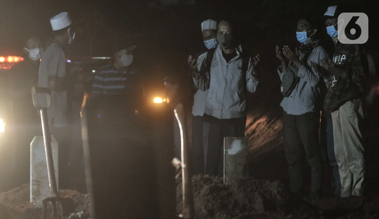Keluarga dan kerabat saat menyaksikan proses pemakaman di TPU Pondok Ranggon, Jakarta, Kamis (24/9/2020). Jumlah kumulatif kasus Covid-19 di Indonesia mencapai 262.022 orang per Kamis (24/9) dengan 191.853 orang dinyatakan sembuh dan 10.105 orang meninggal dunia. (merdeka.com/Iqbal Nugroho)
