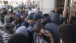 Antrean orang-orang untuk memasuki toko Niketown di London, Senin (15/6/2020). Antrean panjang terjadi di luar toko-toko yang berada di sejumlah kota di Inggris saat negara itu melakukan pelonggaran lockdown dan mulai membuka pusat perbelanjaan. (AP/Matt Dunham)