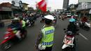 Personel polisi mengatur arus lalu lintas di jalur pantai utara (pantura) Cirebon, Jawa Barat, Kamis (22/6). Tiga hari menjelang lebaran, pemudik pengguna sepeda motor yang melintas di jalur Cirebon meningkat signifikan. (Liputan6.com/Johan Tallo)