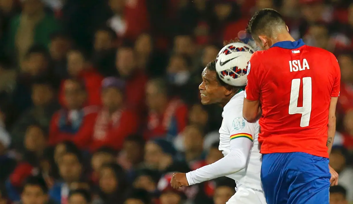 Bek Chile, Mauricio Isla (kanan) berebut bola udara dengan pemain Bolivia saat pertandingan Copa Amerika 2015 di Estadio Nacional, Santiago, Chile, (20/6/2015). Chile menang telak 5-0 atas Bolivia. (REUTERS/Henry Romero)