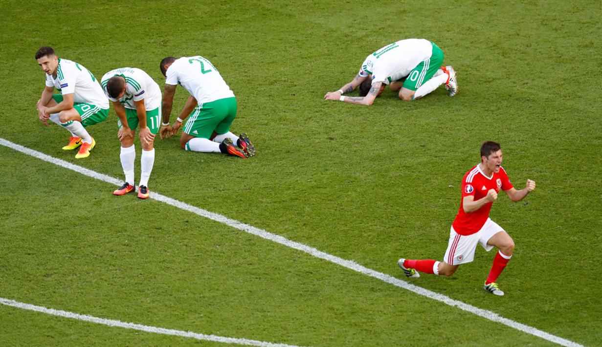 Wales menang 1-0 atas Irlandia Utara pada laga 16 besar Piala Eropa 2016 di Parc des Princes, Paris, Sabtu (25/6/2016) malam WIB. Gol tunggal kemenangan Wales tercipta setelah Gareth McAuley melakukan gol bunuh diri. (Reuters/Christian Hartmann)
