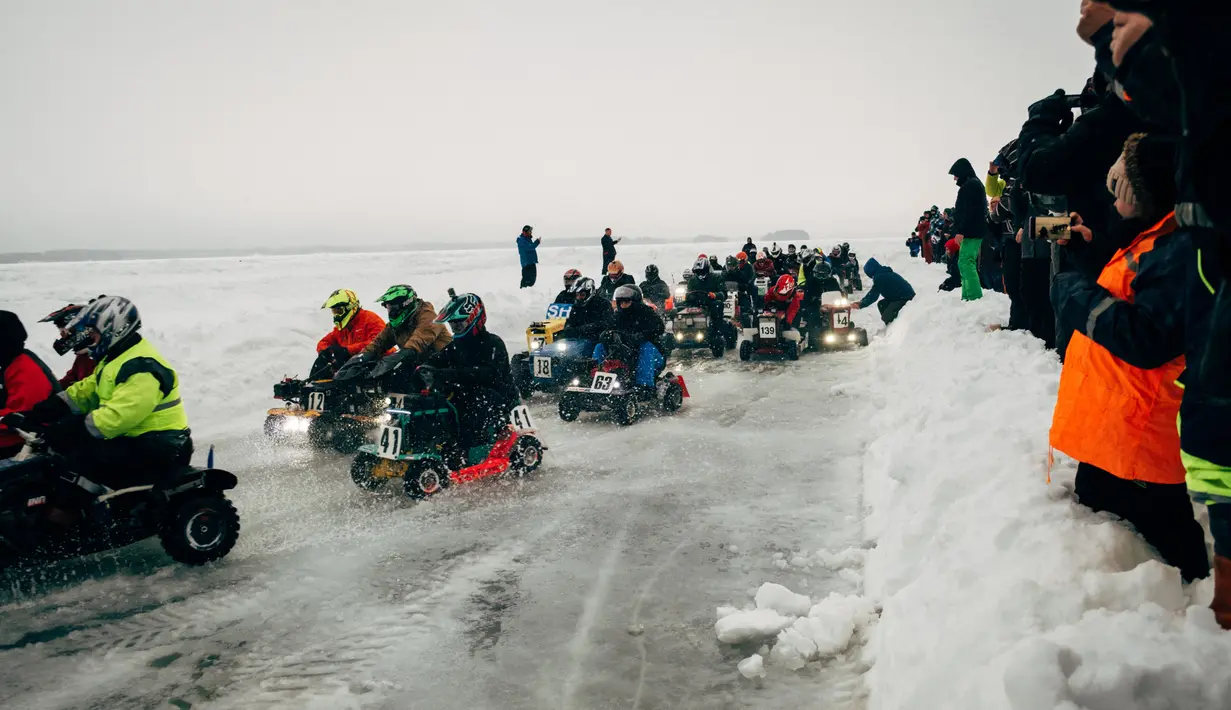 Peserta berkompetisi dalam kejuaran balap mesin potong rumput tahunan di Lavia, Finlandia, 9 Februari 2019. Para pembalap harus menyelesaikan sebanyak mungkin putaran di area pertandingan yang tertutup salju. (Alessandro RAMPAZZO/AFP)