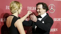 Aktor Johnny Depp saat akan memeluk aktris Kate Winslet saat menghadiri Gala Annual Palm Springs International Film Festival Awards ke-27 di California, (2/1). Johnny Depp turut serta mengajak istrinya dalam acara ini. (REUTERS/Danny Moloshok)