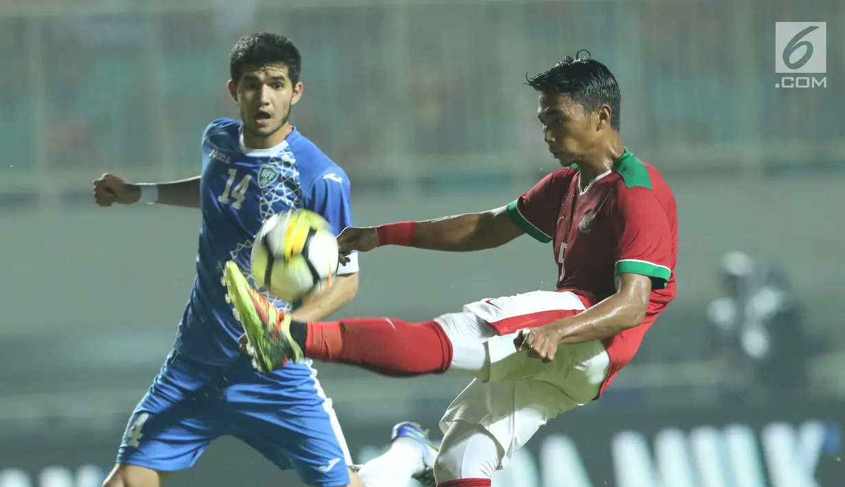 Pemain belakang Indonesia U-23, Bagas Adi Nugroho (kanan) berebut bola dengan pemain Uzbekistan pada laga PSSI Anniversary 2018 di Stadion Pakansari, Kab Bogor, Kamis (3/5). Babak pertama berakhir imbang 0-0. (Liputan6.com/Helmi Fithriansyah)