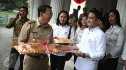 Koordinator relawan Ahok-Djarot, Dodi (kanan) memberikan roti buaya kepada Gubernur DKI Basuki Tjahaja Purnama di Balai Kota Jakarta, Senin (29/8). Roti buaya itu simbol warga meminang Ahok-Djarot pada Pilkada DKI Jakarta 2017 (Liputan6.com/Faizal Fanani)