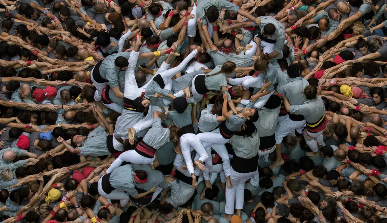 Anggota "Castellers de Sants" membentuk menara manusia selama Kompetisi Tower Manusia di Tarragona, Spanyol, Minggu (7/10). Tradisi "Castells" atau "Menara Manusia" ini merupakan kegiatan rutin setiap dua tahun sekali (AP/Emilio Morenatti)