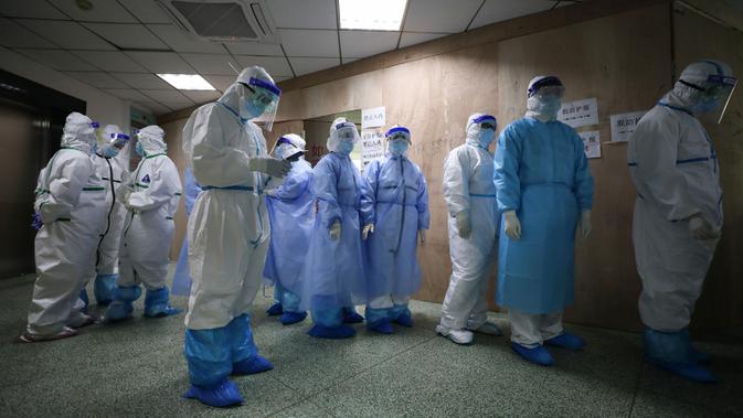 Petugas medis antre untuk melepas jas pelindung sebelum pulang kerja di Rumah Sakit Palang Merah di Wuhan pada 28 Februari 2020. Jumlah korban meninggal akibat virus corona (Covid-19) di seluruh dunia hingga Minggu (8/3) pagi sudah mencapai 3.570 orang, terbanyak masih di China. (STR/AFP)