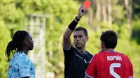 Wasit Luca Zufferli memberikan kartu merah kepada pemain Portugal, Rafael Leao, kiri, dan pemain Chile, Ivan Roman, selama pertandingan persahabatan internasional antara Portugal dan Chile di Oeiras, di luar Lisbon, Sabtu, 6 Juni 2026. (AP Photo/Armando Franca)