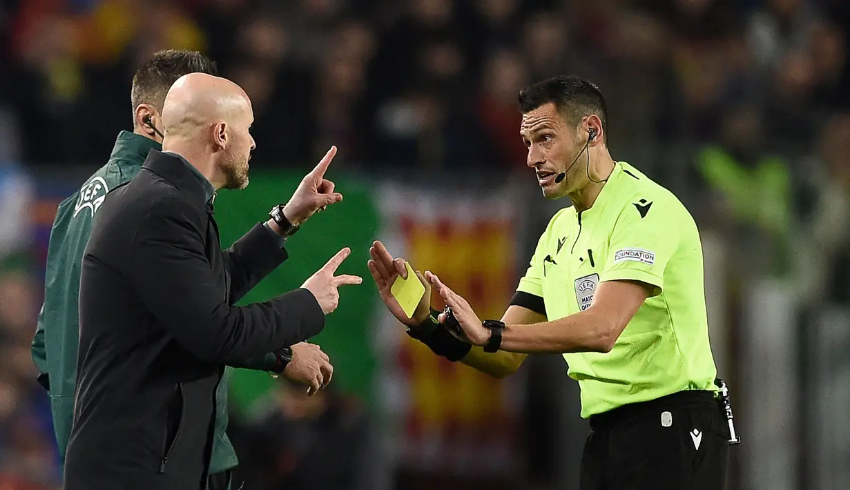 Pelatih Manchester United Erik Ten Hag, mendapatkan kartu kuning dari wasit Maurizio Mariani dalam pertandingan leg pertama play-off babak gugur Liga Europa 2022/2023 yang berlangsung di Camp Nou, Jumat (17/2/2023). (AFP/Josep Lago)