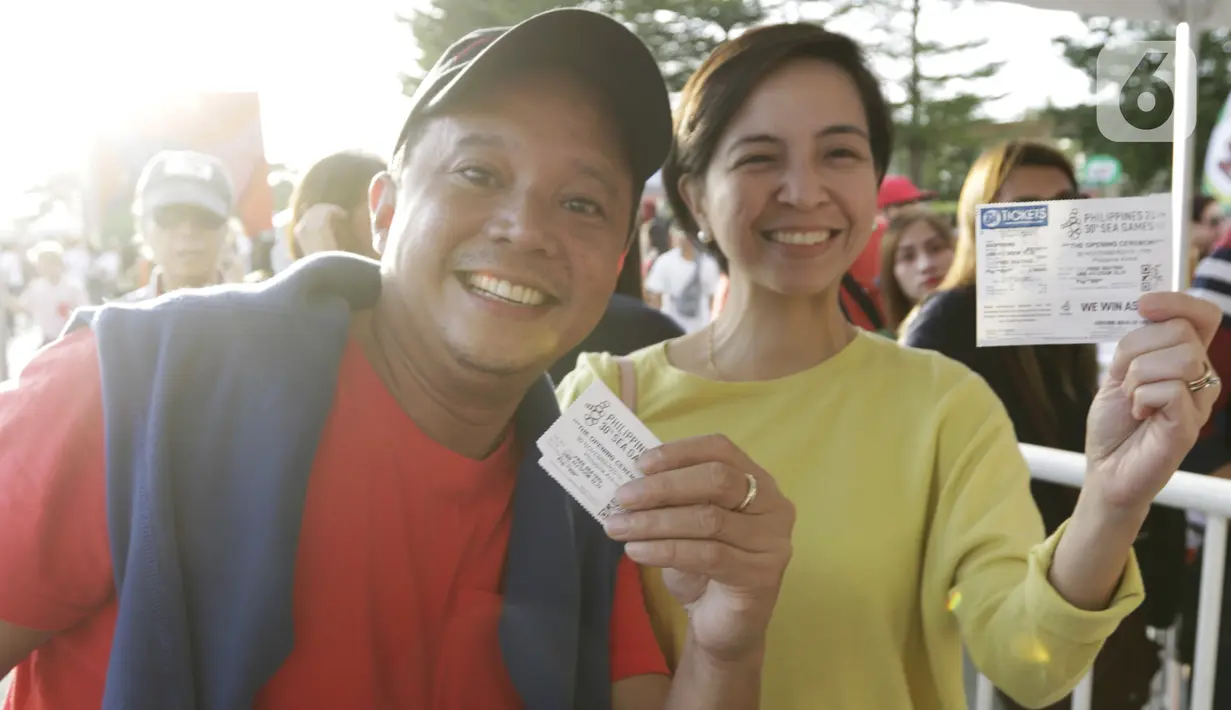 Sepasang penonton menunjukan tiket masuk jelang upacara pembukaan SEA Games 2019 di Philipine Arena Bulacan, Manila, Sabtu (30/11/2019). Pesta olahraga se-Asia Tenggara ini akan berlangsung hingga 11 Desember. (Bola.com/M Iqbal Ichsan)