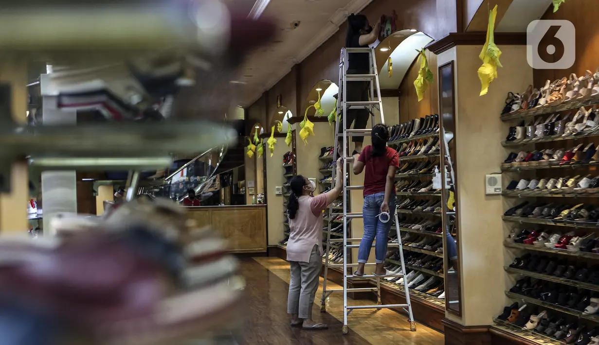 Karyawan memasang ornamen untuk mempercantik toko jelang bulan suci Ramadhan di Pasar Baru, Jakarta, Rabu (9/3/2022). Selain untuk mempercantik toko, pemasangan ornamen juga untuk menarik perhatian pengunjung atau warga yang hendak berbelanja ke toko tersebut. (Liputan6.com/Johan Tallo)
