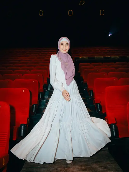 Dhini Aminarti terlihat elegan dalam balutan dress putih panjang berlengan puffy saat premiere film. Paduan hijab panjang warna pink bikin tampilannya jadi lebih feminin [@dhiniaminarti]