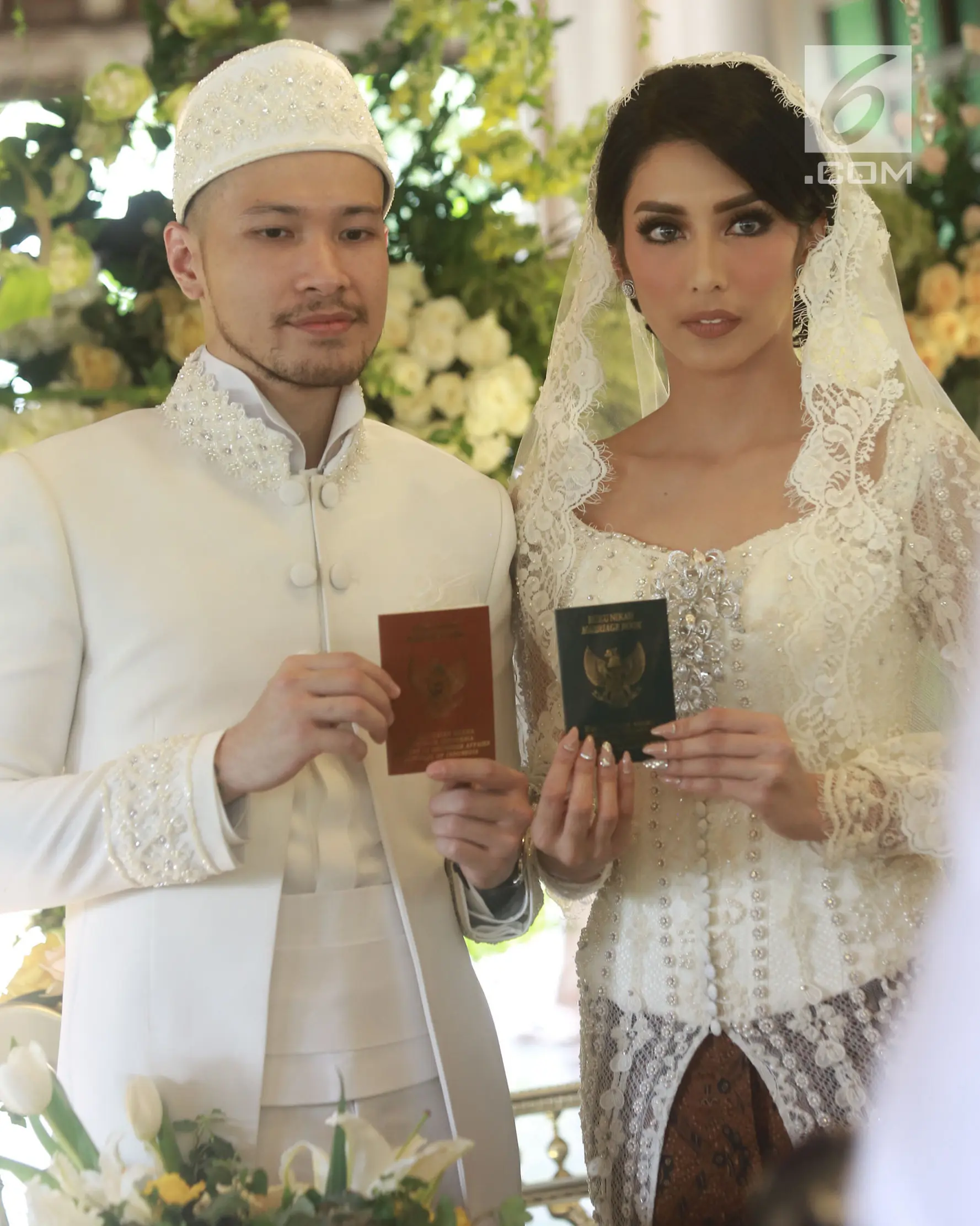 Aktris Tyas Mirasih dan suaminya Raiden Soedjono menunjukkan buku pernikahan usai ijab kabul di kawasan Cilandak, Jakarta (8/7). Tyas Mirasih menikah dengan Raiden Soedjono dengan mas kawin perhiasan emas delapan gram. (Liputan6.com/Herman Zakharia)