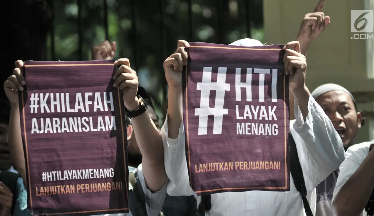 Massa dari HTI membentangkan poster saat menunggu putusan sidang gugatan di luar Gedung Pengadilan Tata Usaha Negara (PTUN), Jakarta, Senin (7/5). (Merdeka.com/Iqbal S Nugroho)