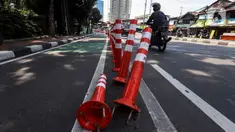 Pengendara melintasi "stick cone" pembatas jalur sepeda di kawasan Pejompongan, Jakarta, Selasa (29/11/2022). Pemprov DKI Jakarta kembali mengganggarkan dana untuk perawatan jalur pembatas sepeda pada rancangan APBD tahun anggaran 2023 sebesar Rp7,5 miliar setelah sebelumnya sempat dicoret dari anggaran dan menuai kecaman dari sejumlah pihak. (Liputan6.com/Johan Tallo)