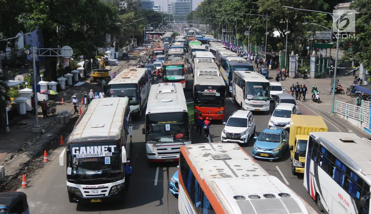 Suasana di Jalan Medan Merdeka Timur saat dipadati puluhan bus yang mengangkut buruh, Jakarta, Selasa (1/5). Berdasarkan data kepolisian, sekitar 30 ribu buruh melakukan aksi May Day 2018 di Jakarta. (Liputan6.com/Arya Manggala)